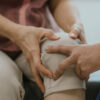doctor checking woman's knee - joint pain