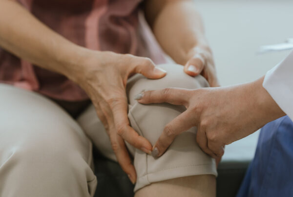 doctor checking woman's knee - joint pain